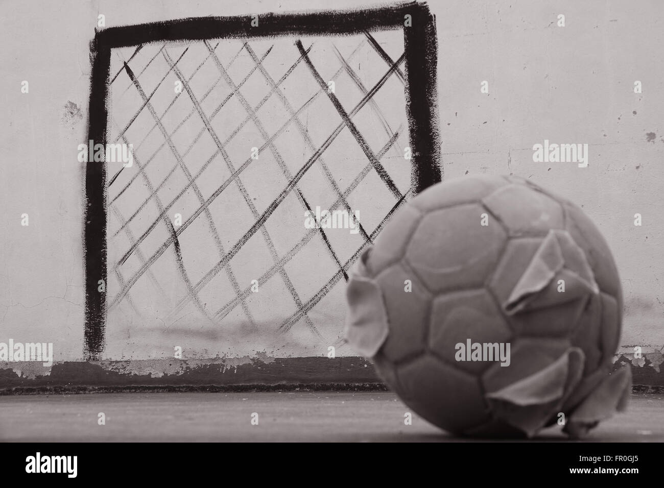 alte Fußball auf dem Betonboden Stockfoto