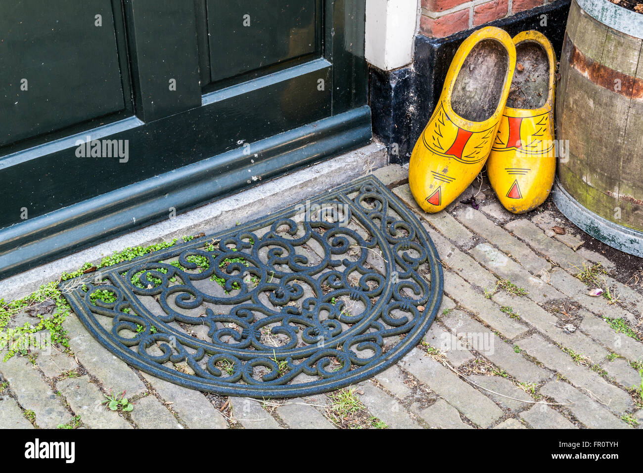 Holzschuhe und Fußmatte vor Eingang Tür des alten Hauses im niederländischen Dorf Scheveningen, den Haag, Niederlande Stockfoto