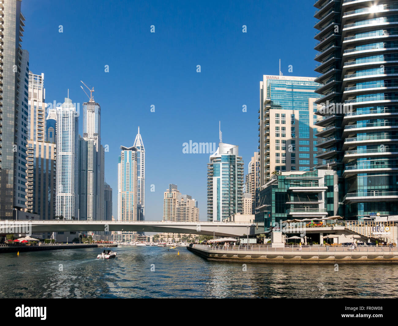 Promenade, Hochhäuser am Wasser, Boote und Brücke im Stadtteil Marina von Dubai, Vereinigte Arabische Emirate Stockfoto