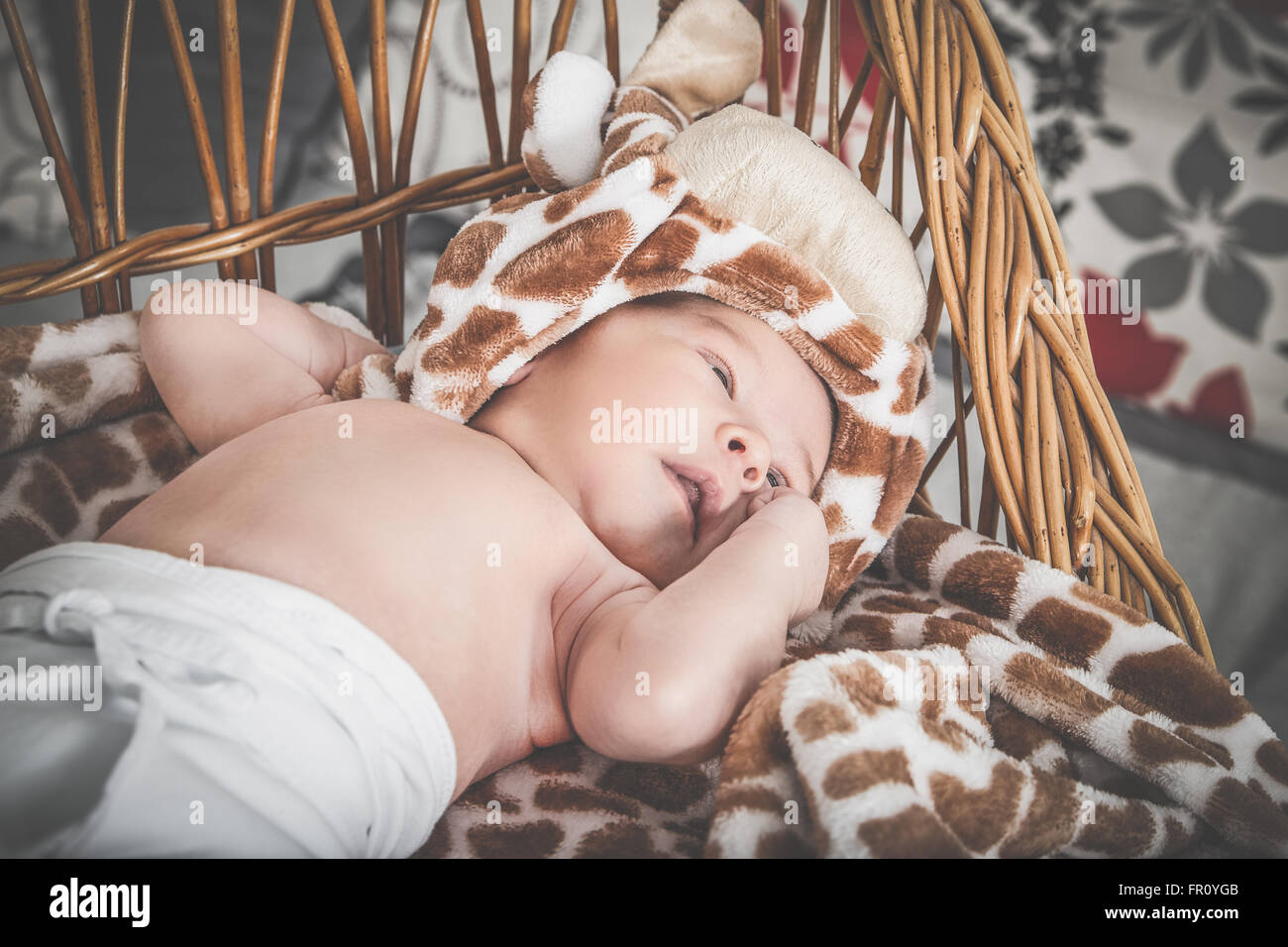 Porträt der Beautiful Boy im Korb liegen. Entzückende Baby schlafend in seiner Wiege durch ein Fenster. Kind schläft in gestrickte Krippe Witz Stockfoto