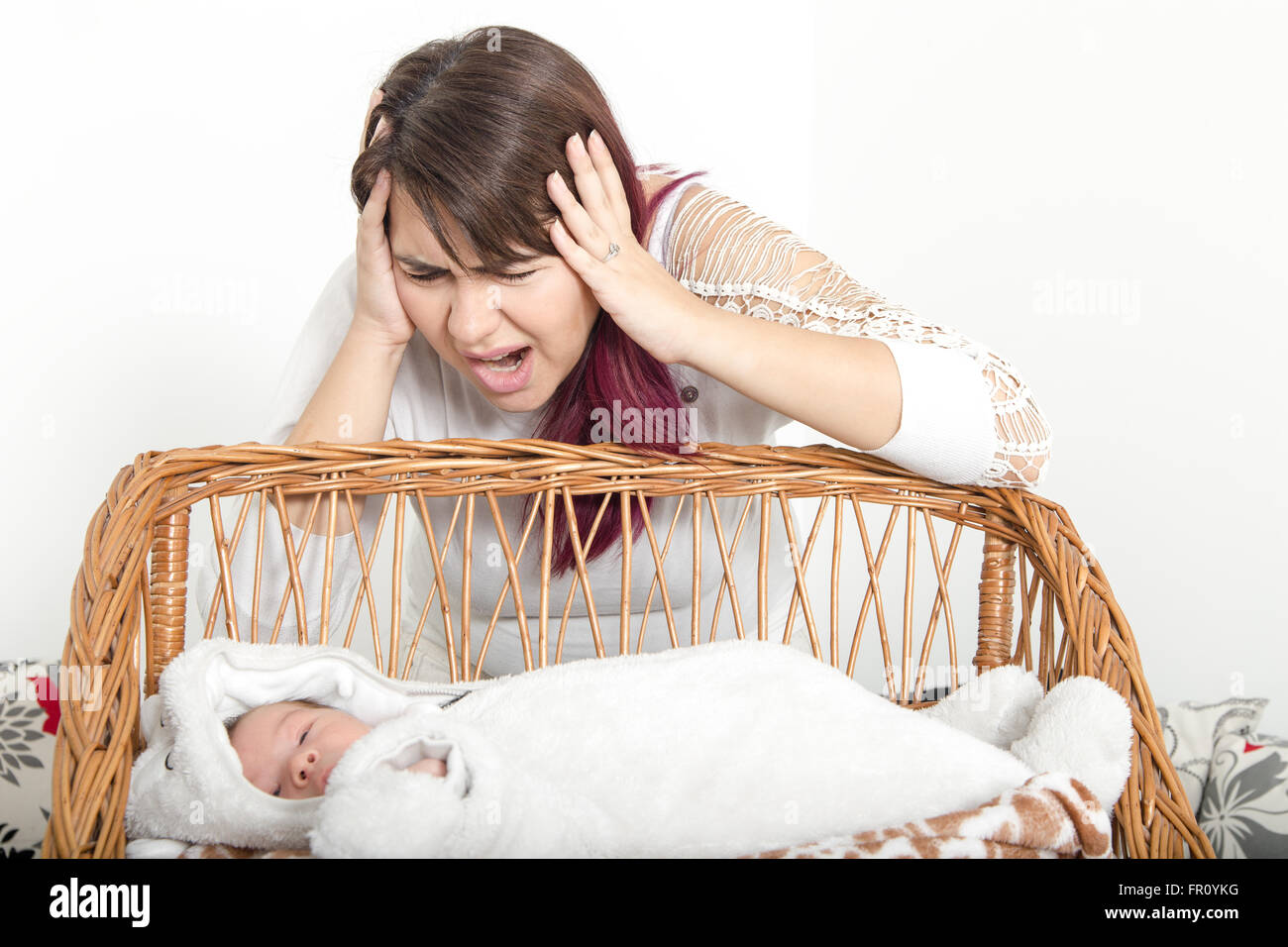 Erschöpfte Mutter verärgert Baby leiden mit Post-Natal-Depression. Mutter hält ihr Baby betont. Frau mit Gesichtsausdruck Stockfoto