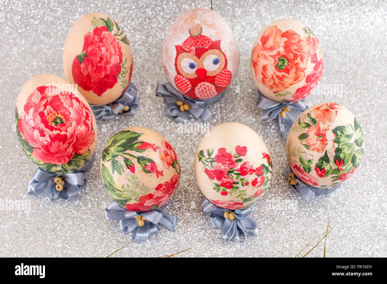 Bunte hausgemachte Serviettentechnik verziert Ostereier glänzend Silber Hintergrund Stockfoto