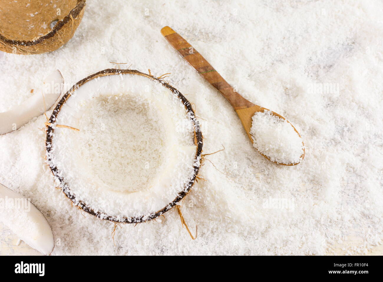 Halbierte frische Kokosnuss und Kokos Pulver auf dem Tisch Stockfoto