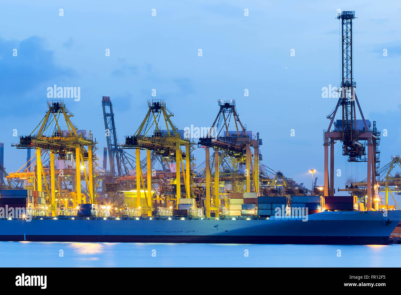 Be- und Entladen Container im Hafen von Singapur während des Abends Stockfoto