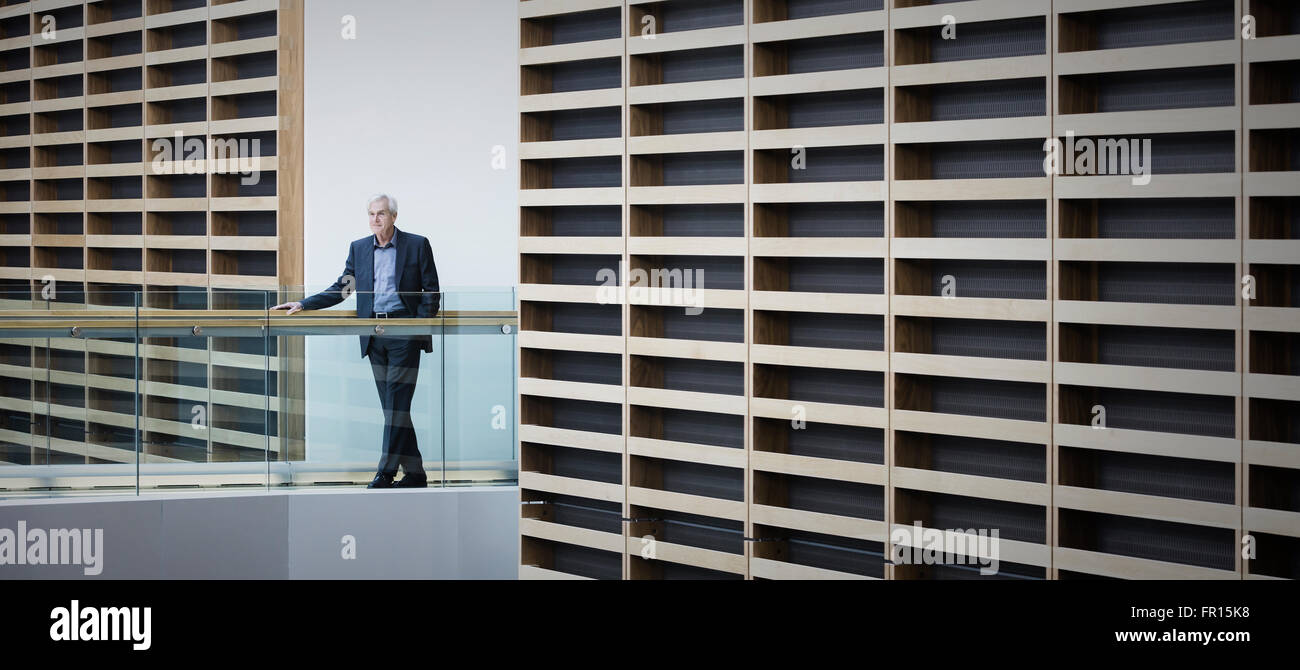 Leitenden Geschäftsmann stehend auf Gehweg in modernen Büro Stockfoto