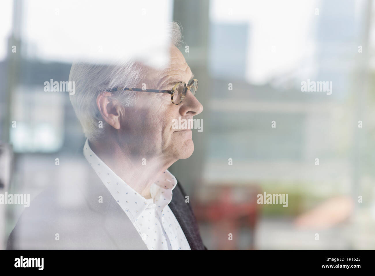 Nachdenklich senior Geschäftsmann Bürofenster mit Blick Stockfoto