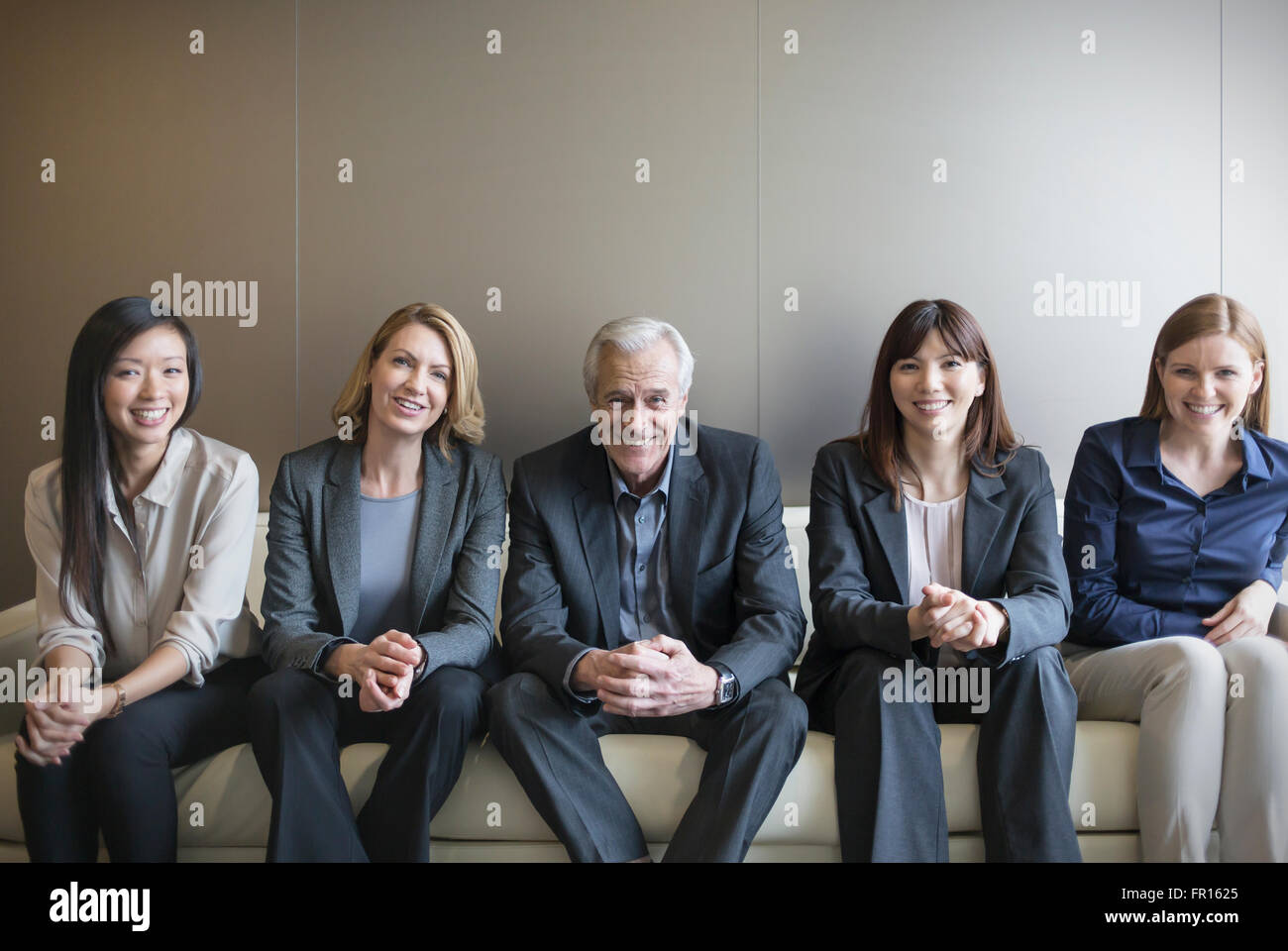 Porträt, Lächeln Geschäftsleute in Folge auf sofa Stockfoto