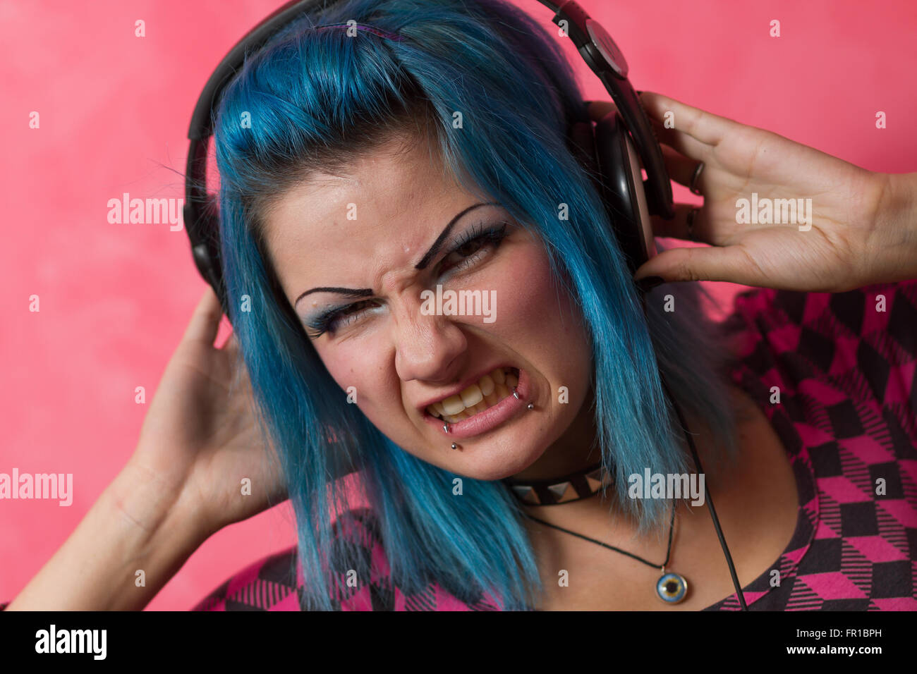 Süße junge Mädchen mit blau gefärbten Hari und rosa Outfit spielen Schallplatten auf eine professionelle Ausrüstung Stockfoto