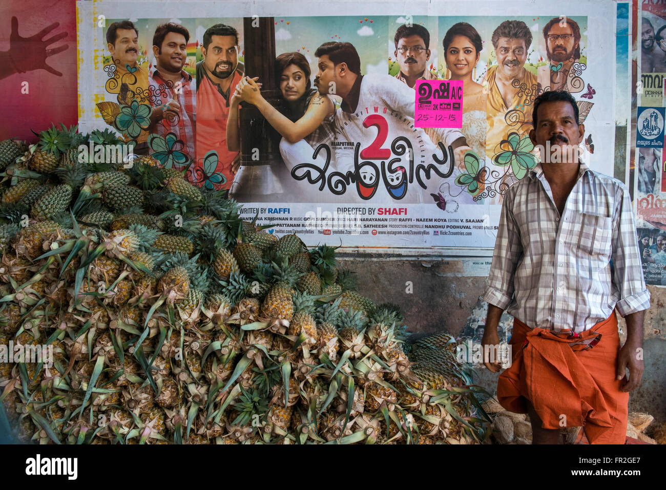 Verkauf von Ananas auf dem Markt vor Filmplakat, Kollam Mann Stockfoto