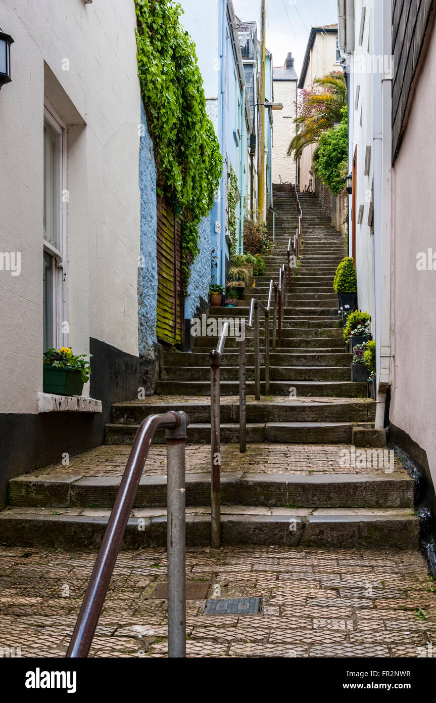 Eine steile Treppe gepflastert mit roten Ziegeln Fliesen Steigungen in einer leichten Kurve nach einem zentralen Handlauf zwischen Pastellfarben gestrichenen Häuser Stockfoto