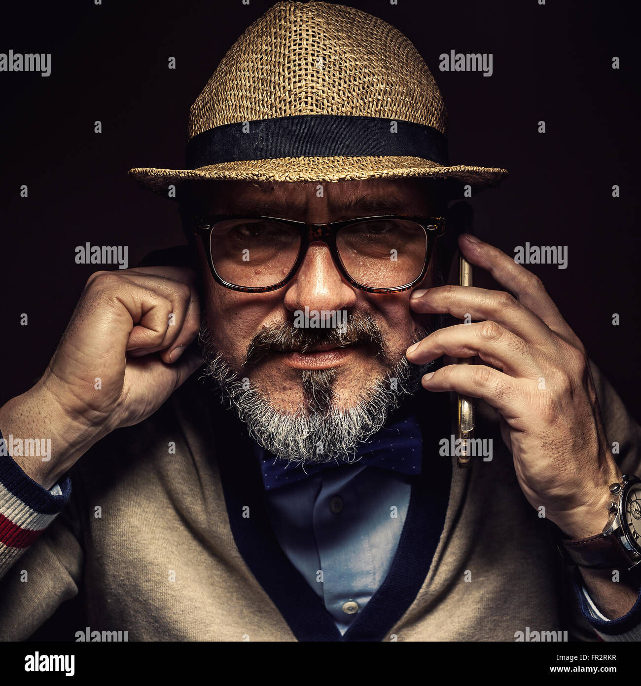 Ältere Person kommunizieren über Handy, Retro-Style Kleidung, Brillen-und Hut. Stockfoto