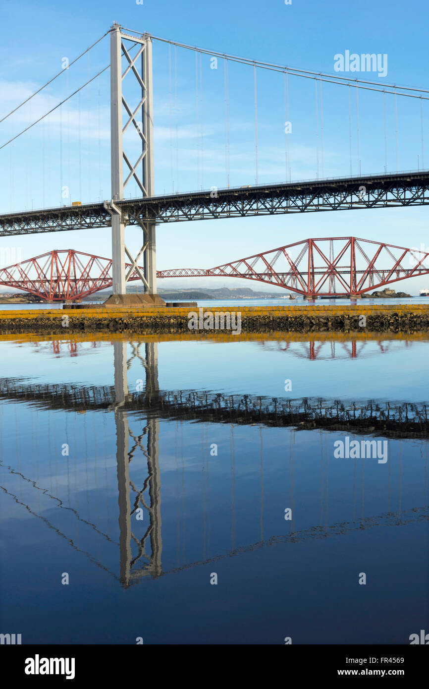 Die Forth Road Bridge und die Forth Rail Bridge spiegelt sich in den ruhigen Gewässern des Firth of Forth, in der Nähe von Edinburgh Stockfoto