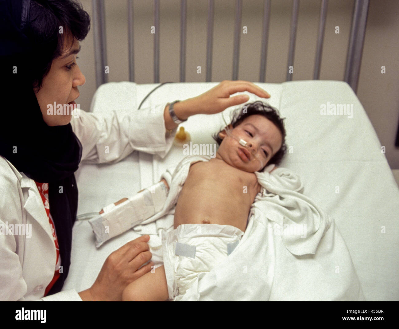 Ein Arzt tendiert zu einem kranken Baby am Klinikum Saudi Aramco in Dhahran. Stockfoto