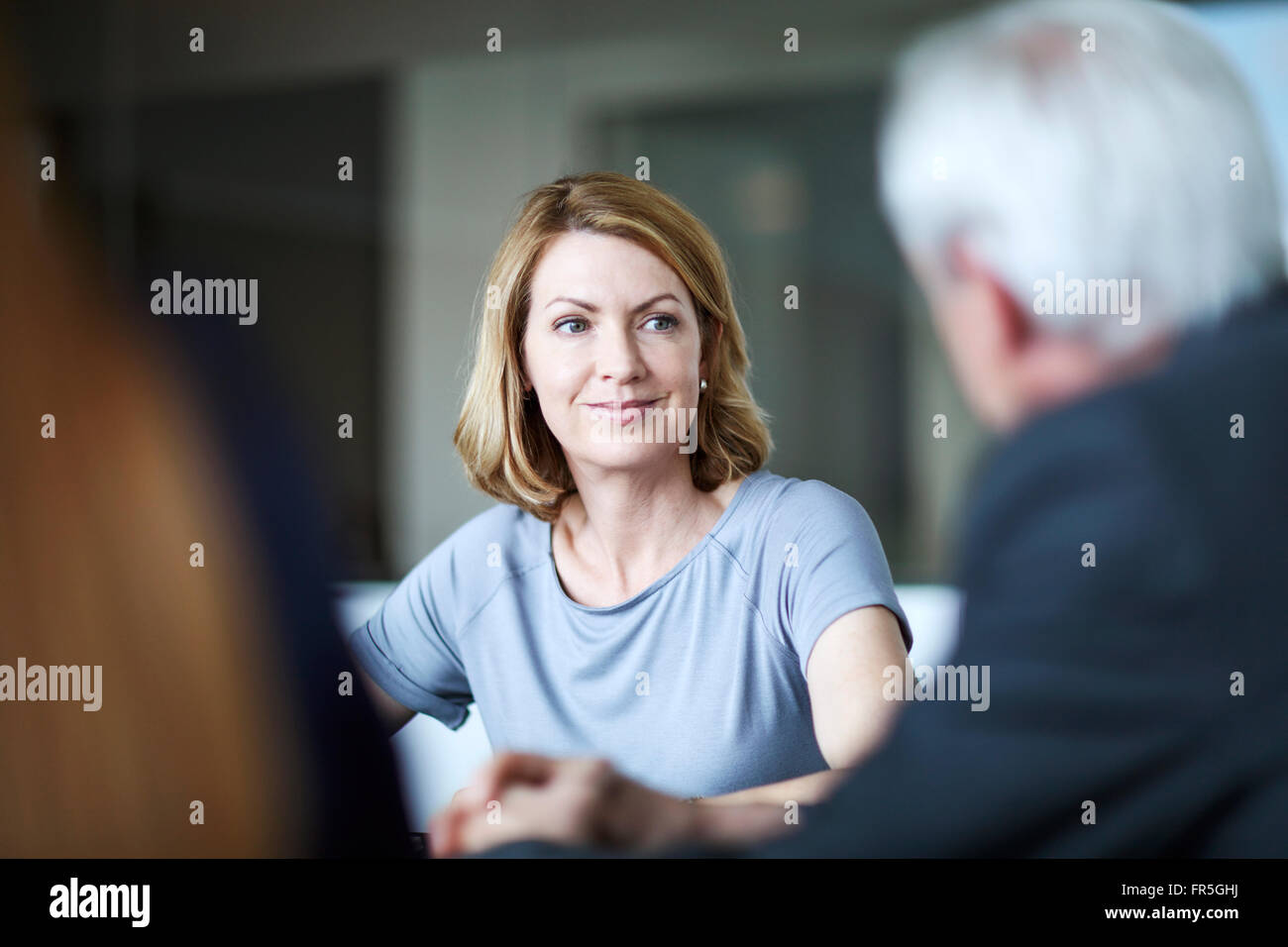 Geschäftsfrau, Geschäftsmann in Besprechung anhören Stockfoto