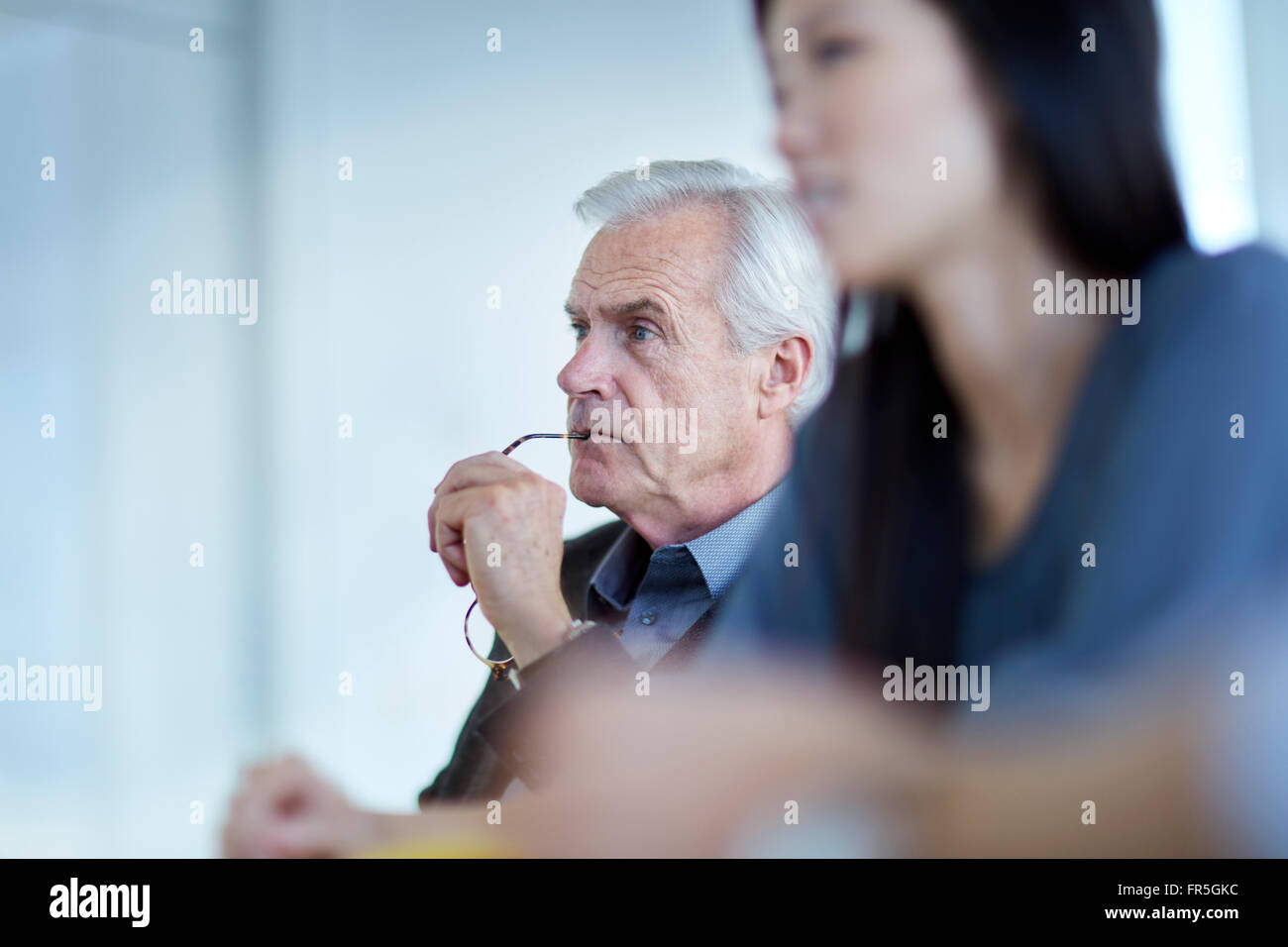 Konzentrierte sich senior Geschäftsmann hören in treffen Stockfoto