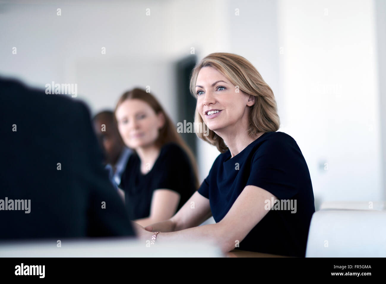 Lächelnde Geschäftsfrau hören in treffen Stockfoto