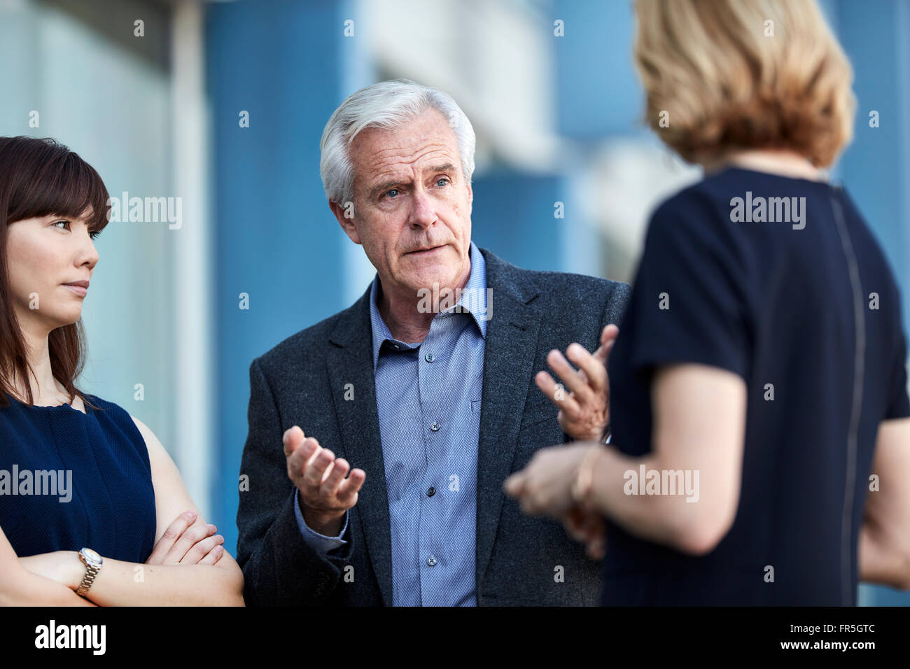 Leitenden Geschäftsmann gestikulieren und im Gespräch mit Kollegen Stockfoto