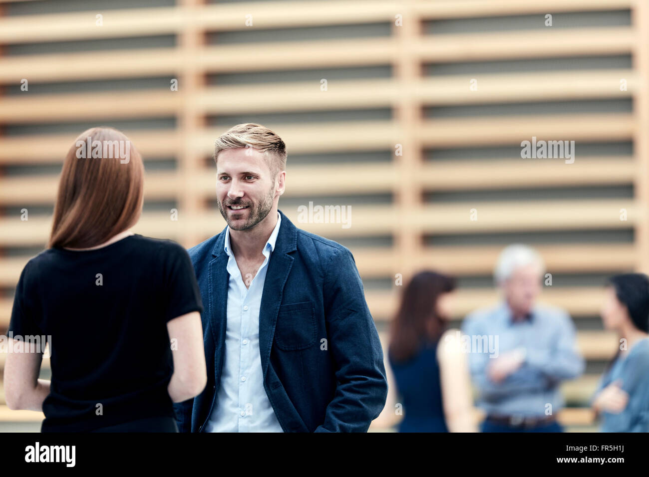 Geschäftsmann und Geschäftsfrau in Lobby sprechen Stockfoto