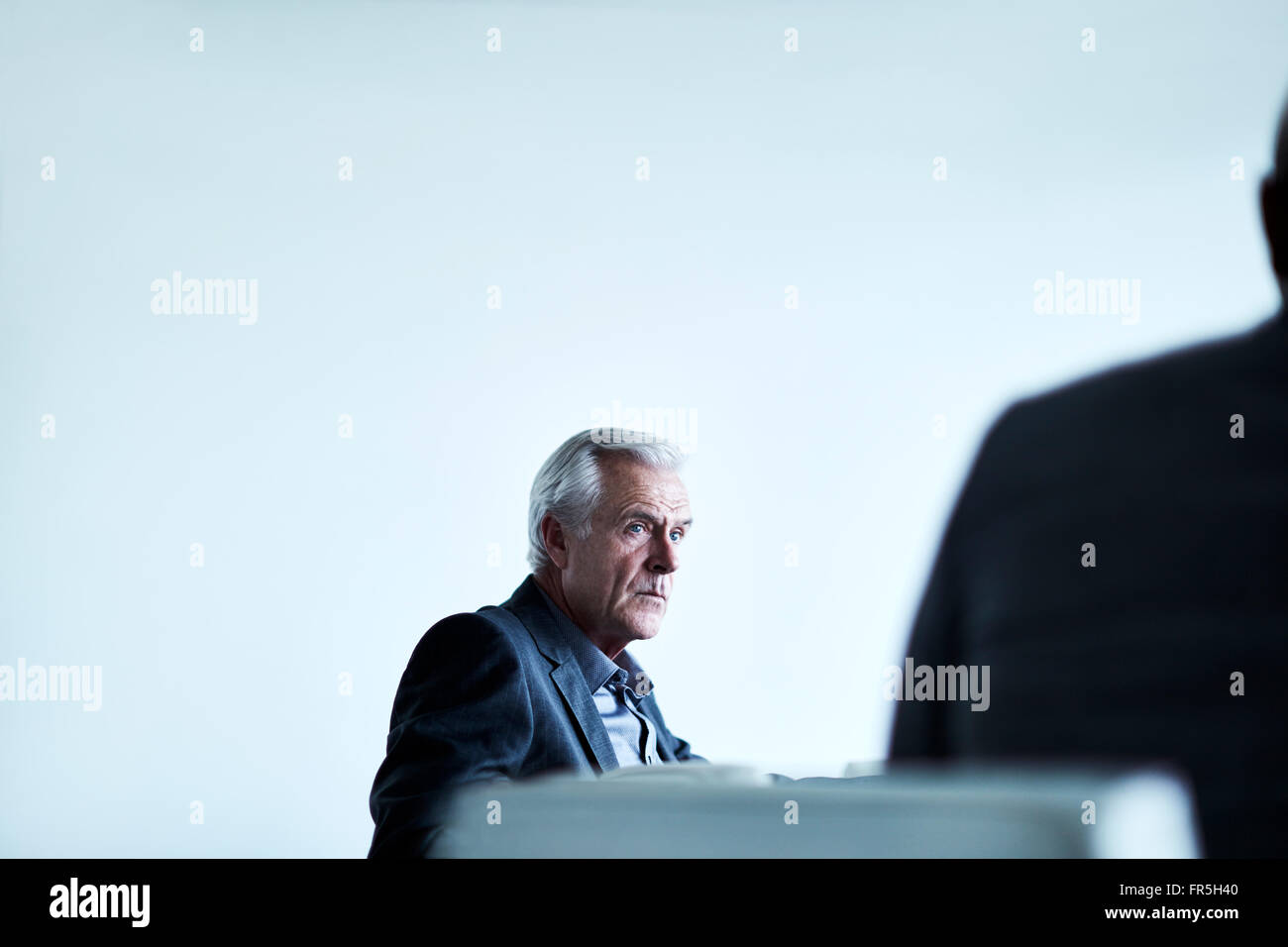 Ernst senior Geschäftsmann hören in treffen Stockfoto