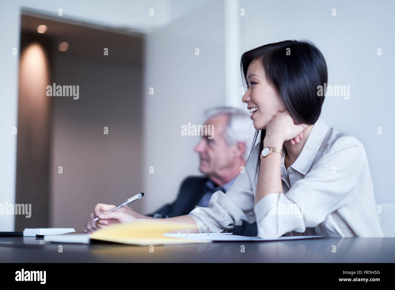 Lächelnde Geschäftsfrau Notizen in Meetings Stockfoto