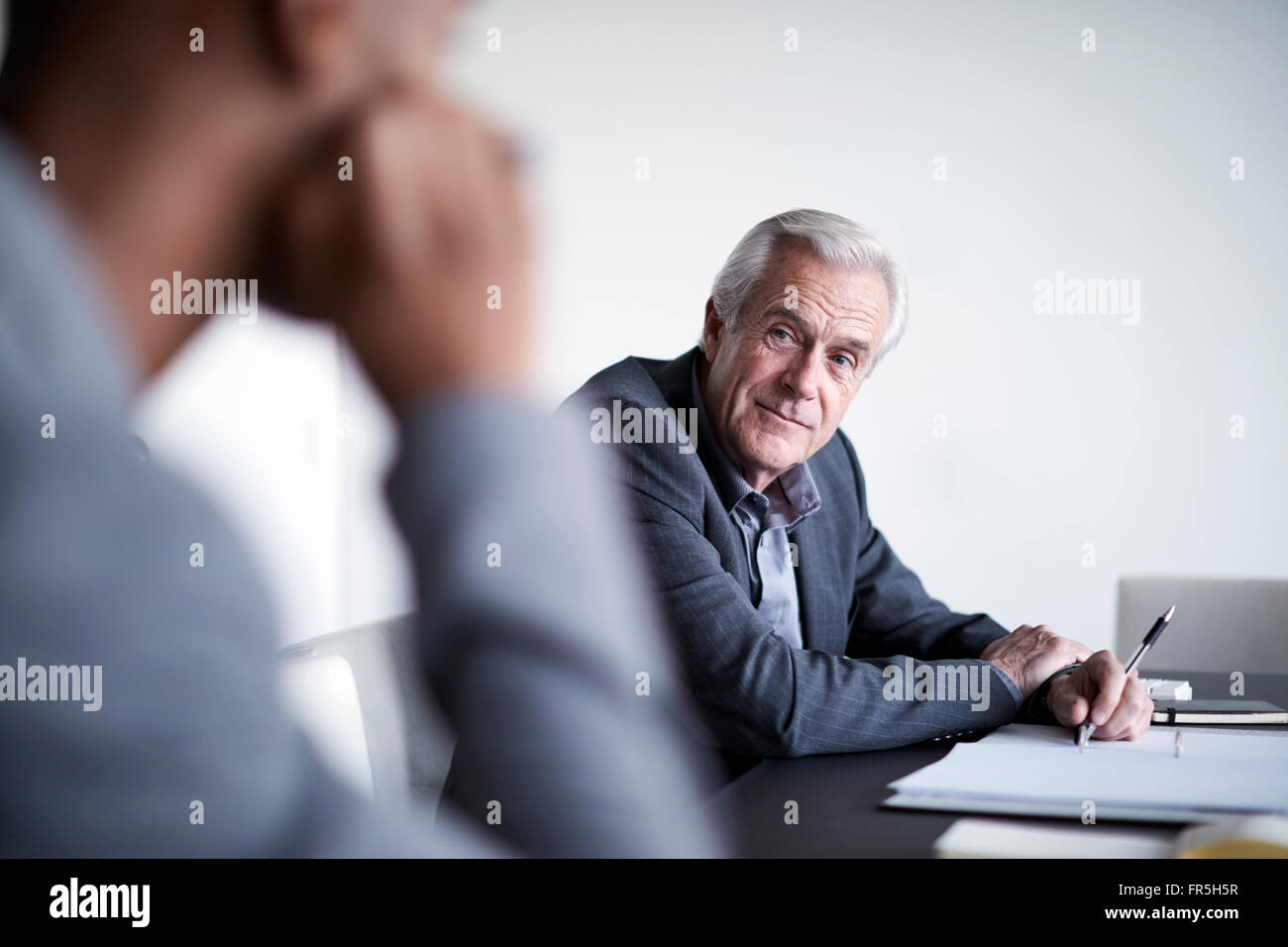 Leitenden Geschäftsmann hören in treffen Stockfoto