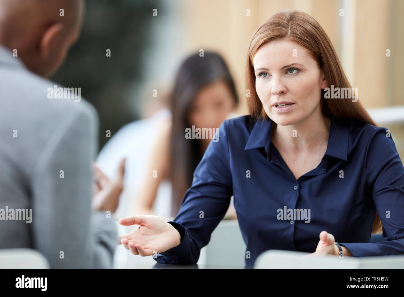 Geschäftsfrau, gestikulieren und im Gespräch mit Geschäftsmann Stockfoto