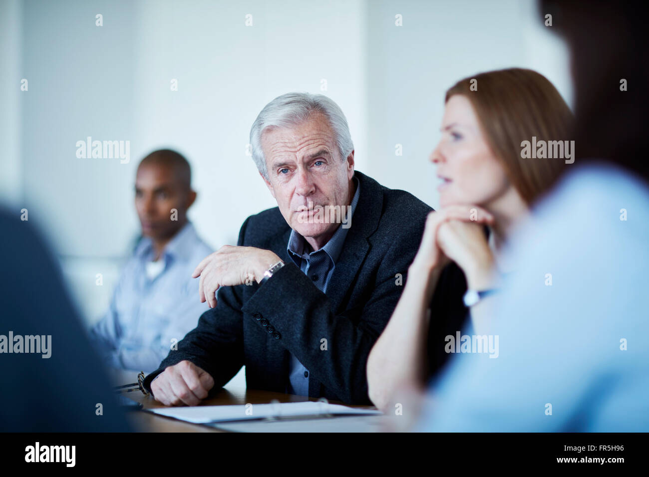 Leitenden Geschäftsmann hören in treffen Stockfoto