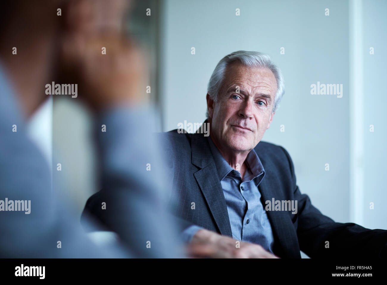 Aufmerksame senior Geschäftsmann hören in treffen Stockfoto