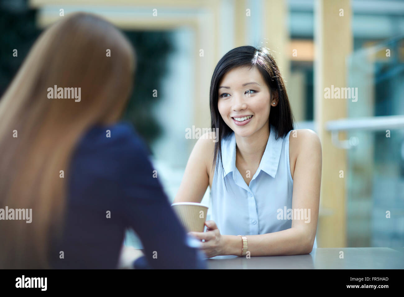 Lächelnde Geschäftsfrauen auf Kaffeepause im Gespräch Stockfoto