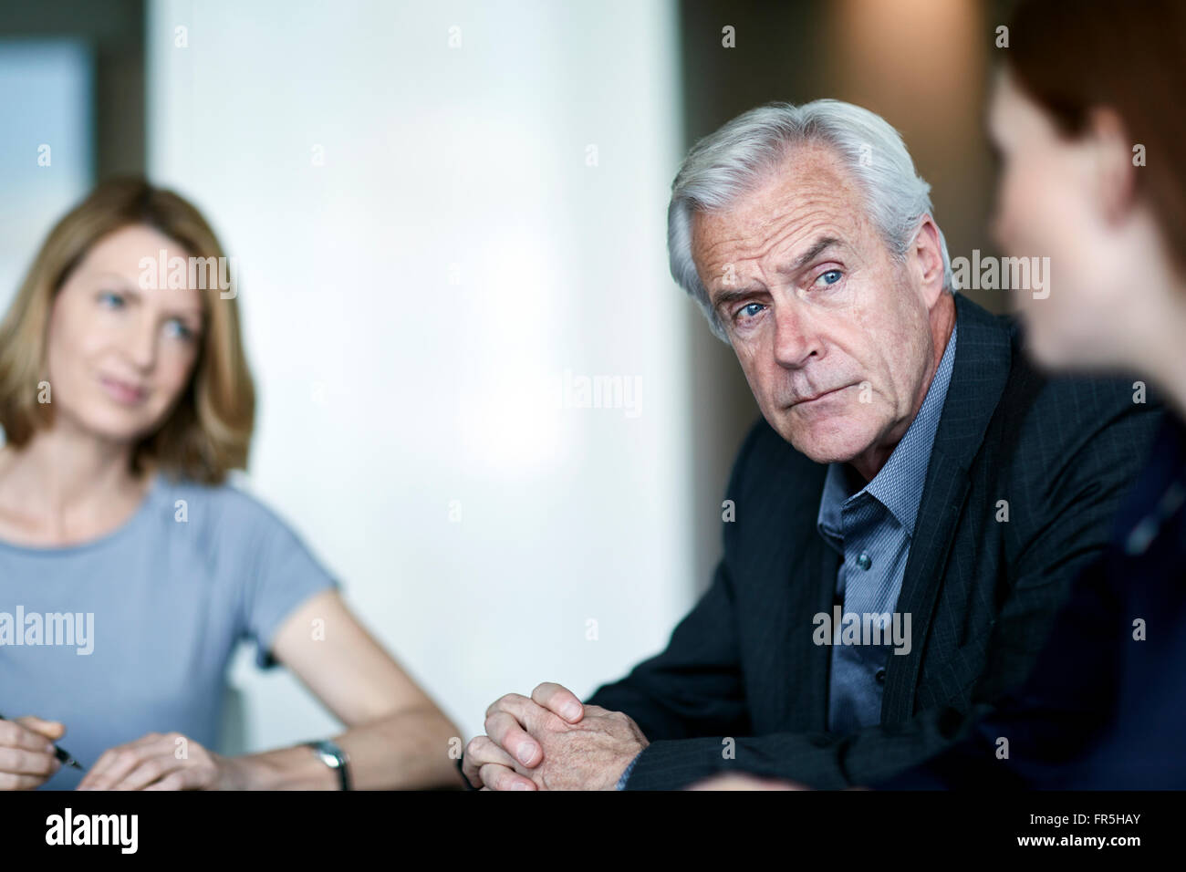 Ernst senior Geschäftsmann, Geschäftsfrau in Besprechung anhören Stockfoto