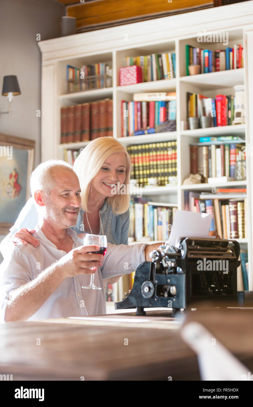 Älteres paar Weintrinken an Schreibmaschine Stockfoto