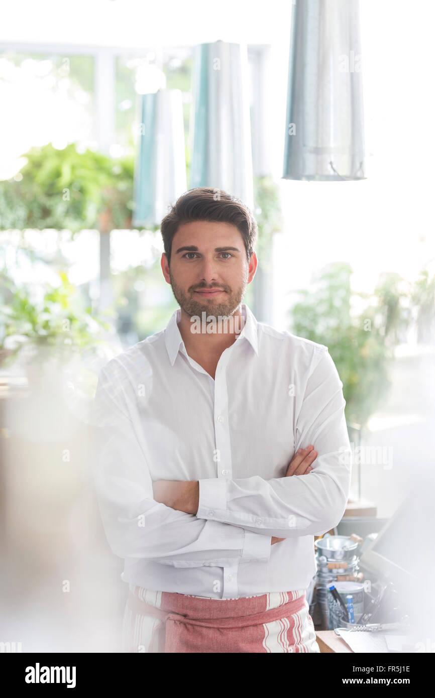 Porträt zuversichtlich Kellner mit verschränkten im café Stockfoto