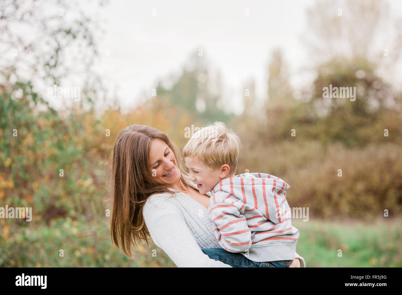 Mutter und Kleinkind Sohn lachend im Herbst park Stockfoto