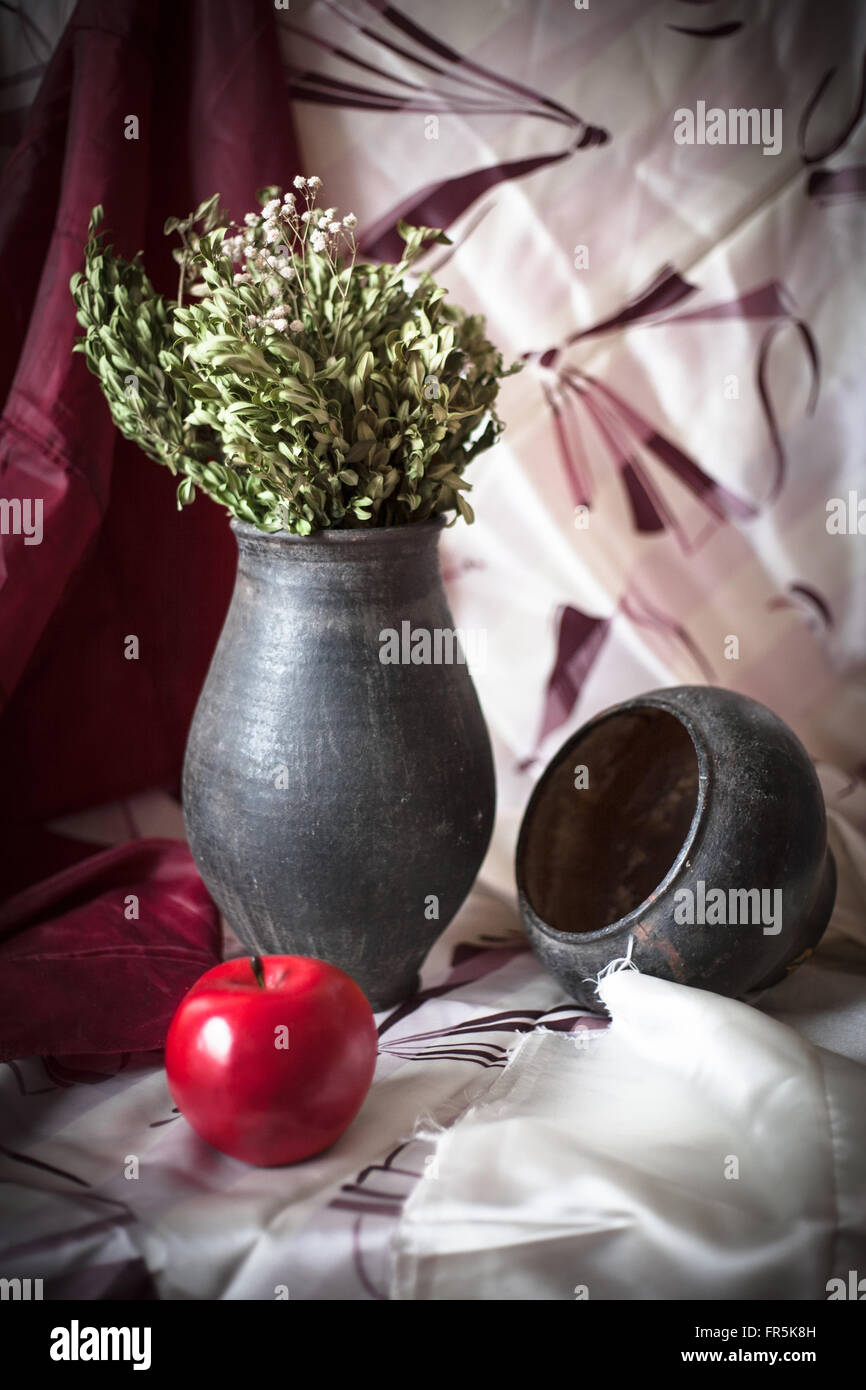 Stillleben mit einem schwarzen Krug und ein roter Apfel auf dem Tisch Stockfoto