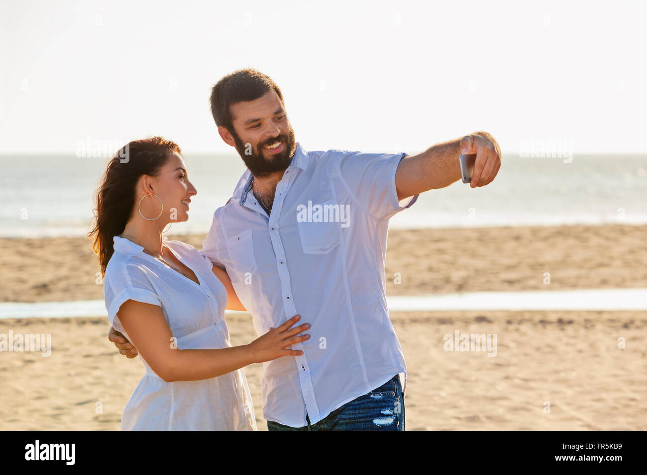 Glückliche Familie auf Hochzeitsreise Urlaub - nur liebevolle Ehepaar Spaß haben und nehmen Selfie für social Network am Meeresstrand. Leben Stockfoto