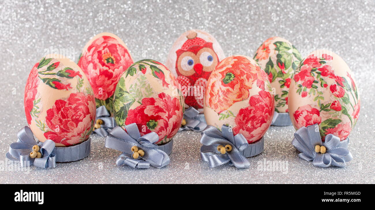 Bunte hausgemachte Serviettentechnik verziert Ostereier glänzend Silber Hintergrund Stockfoto