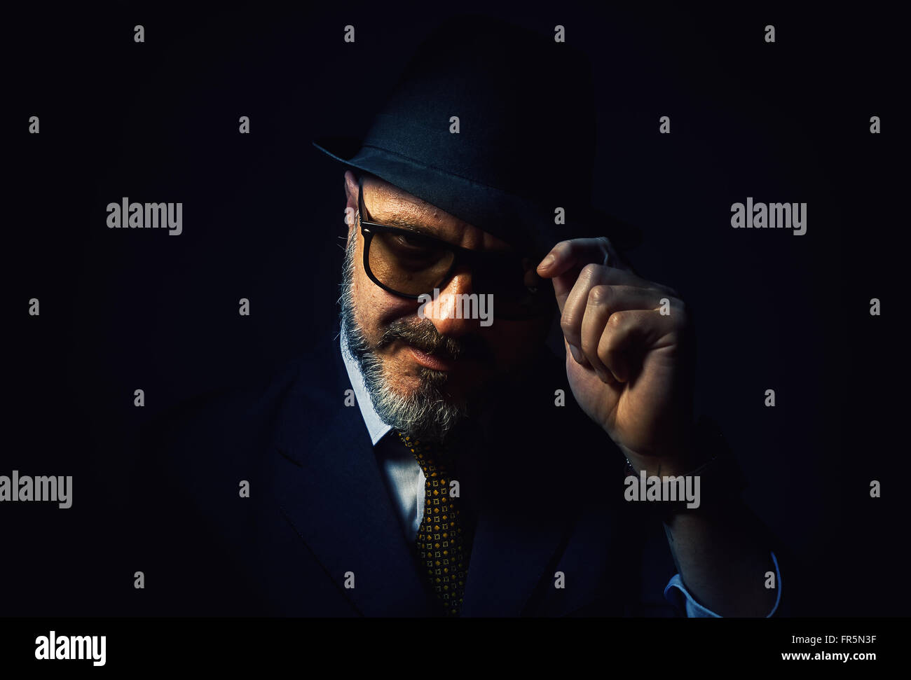 Ältere Bart Mann respektvoll, hält einen Hut, eine klassische männliche Kleidung mit Krawatte zu tragen. Stockfoto