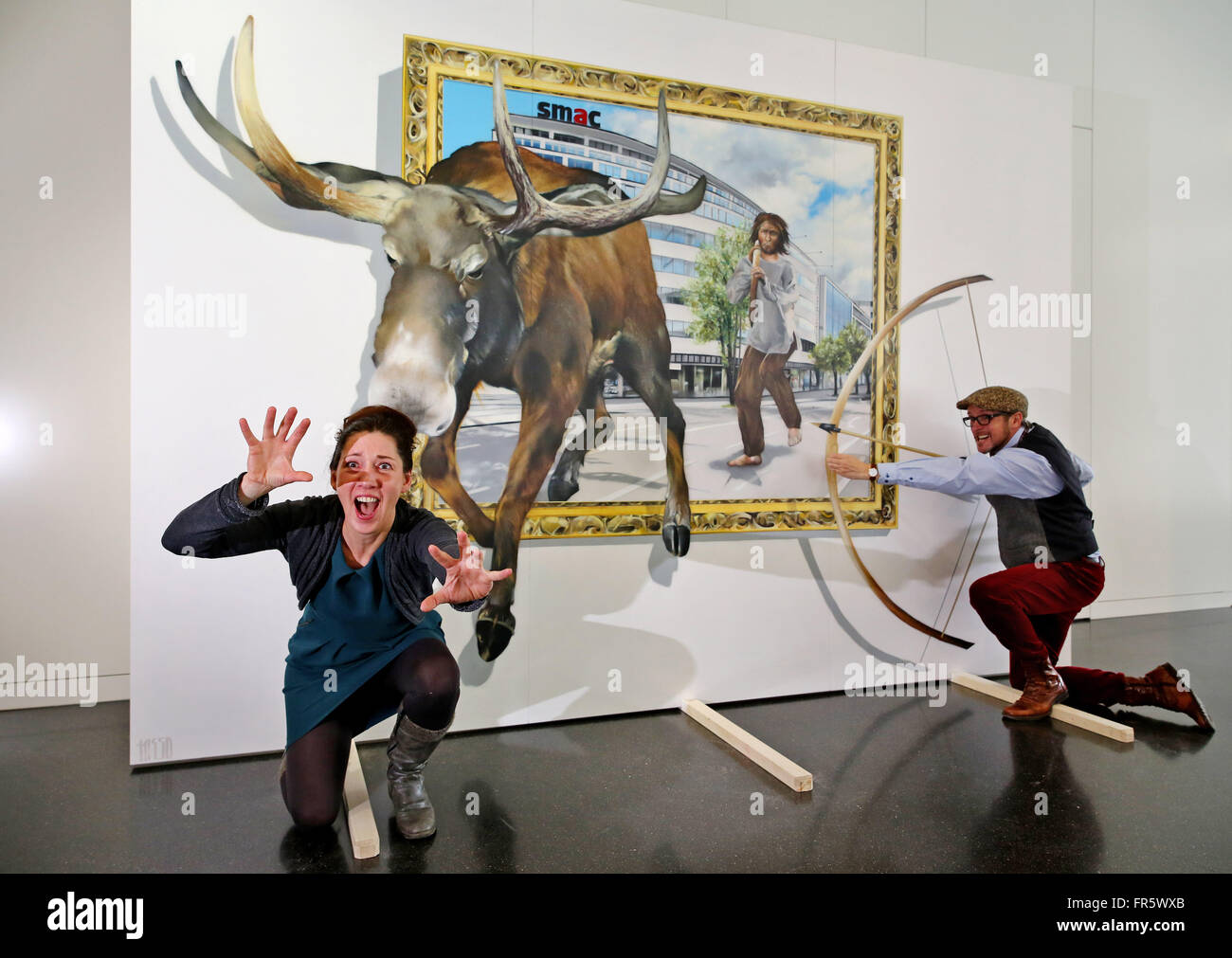 Museum-Assistentin Jutta Boehme und Graffiti-Künstler Tasso (r) testen die Wirkung eines neuen 3D Bildes Darstellung einer Steinzeit Elch zu jagen im öffentlichen Museum für Archäologie in Chemnitz, Deutschland, 21. März 2016. Die 3D Illusionsmalerei auf einer mobilen 3,6 x 2,5 Meter große Fläche wird in den nächsten zwei Wochen im Museum ausgestellt. Danach gehen die Malerei auf Tour, das archäologische Museum zu werben. Foto: Jan Woitas/dpa Stockfoto