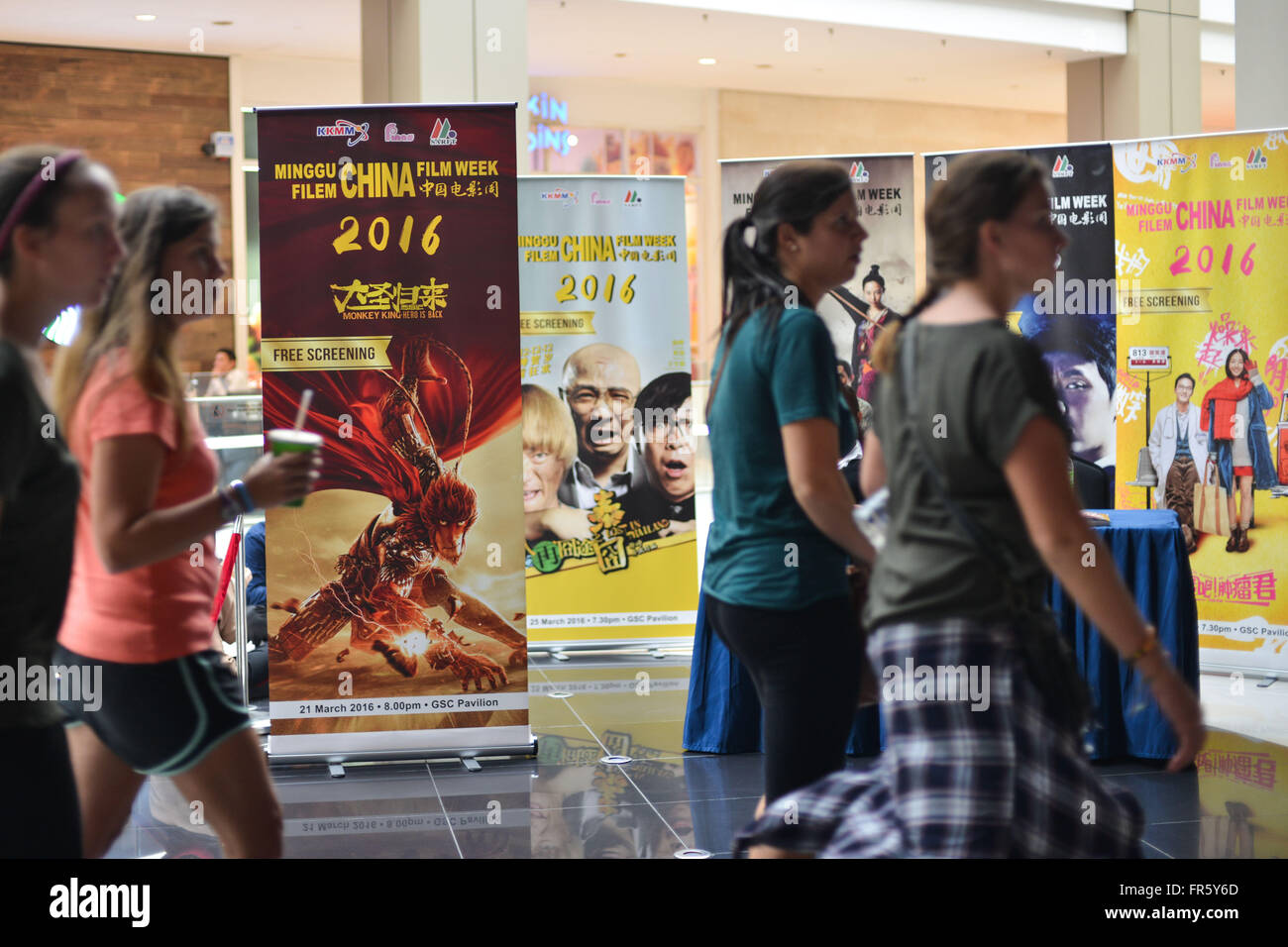 (160322) - KUALA LUMPUR, März. 22, 2016 (Xinhua)--Menschen gehen vorbei an die Plakate von chinesischen Filmen Wochentags 2016 China Film in Kuala Lumpur, Malaysia, März. 21, 2016. Die 2016 startete China Film Week hier am Montag, wie Organisatoren hoffen, dass die animierte Figur wie Monkey King auf der großen Leinwand gezeigt Austausch zwischen Filmemacher und Menschen zwischen China und Malaysia stärken würde. (Xinhua/Chong Voon Chung) (dh) Stockfoto