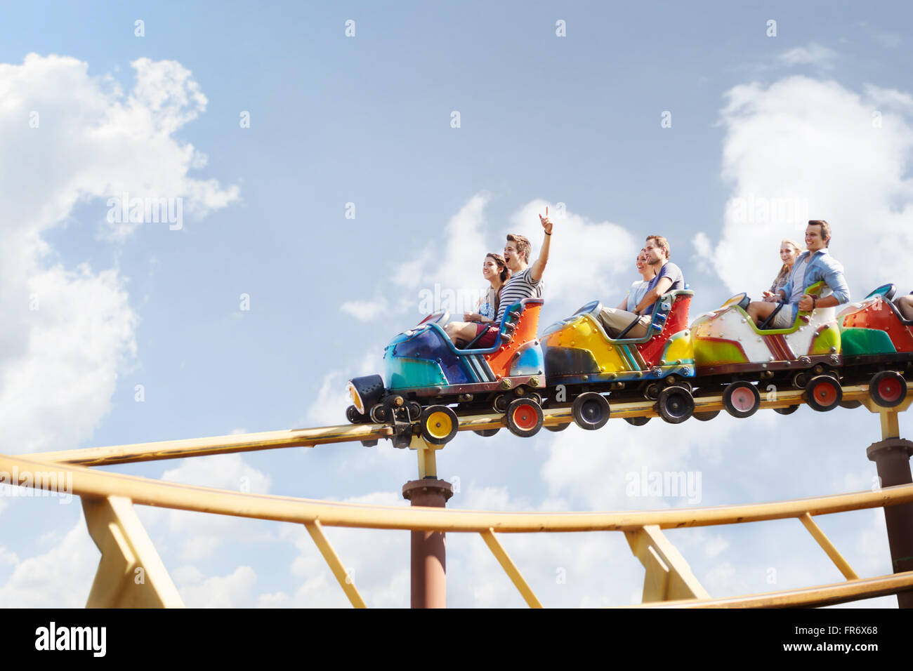 Freunde jubeln fahren Achterbahn im Freizeitpark Stockfoto
