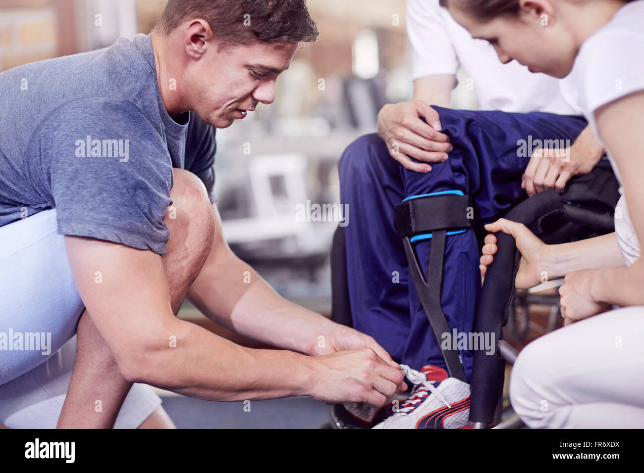 Physiotherapeut des Mannes Schuhe binden Stockfoto