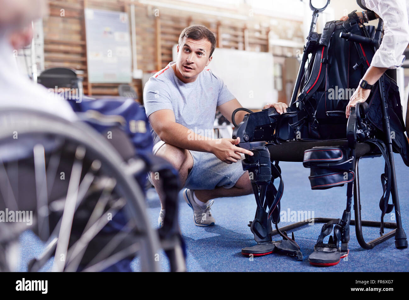 Physiotherapeut erklärt Ausrüstung Mann im Rollstuhl Stockfoto