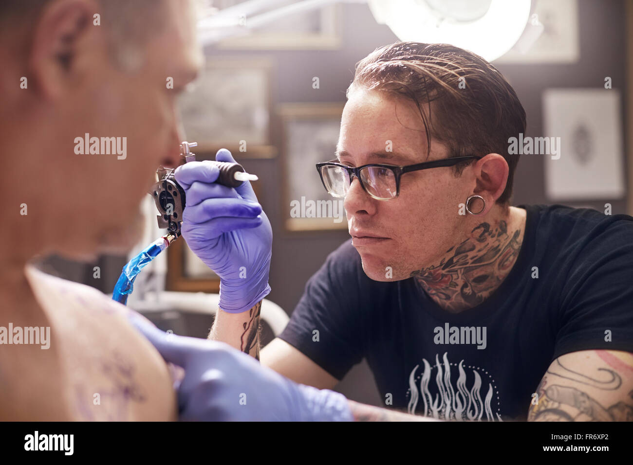 Konzentrierte Vorbereitung Tattoo Gun Tattoo-Künstler Stockfoto
