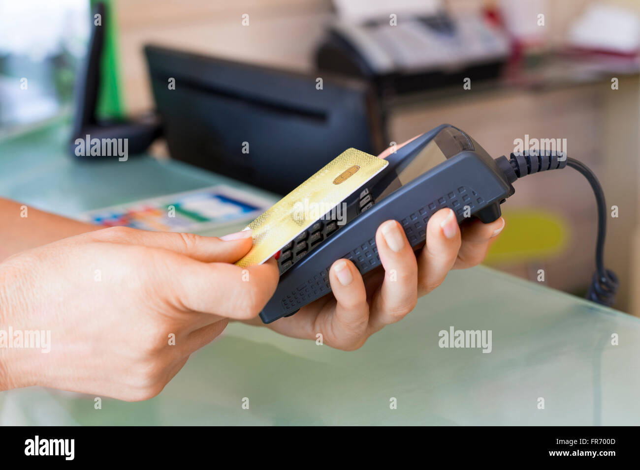 Frau mit NFC-Technologie auf Kreditkarte im Shop bezahlen. Kontaktloses bezahlen Stockfoto