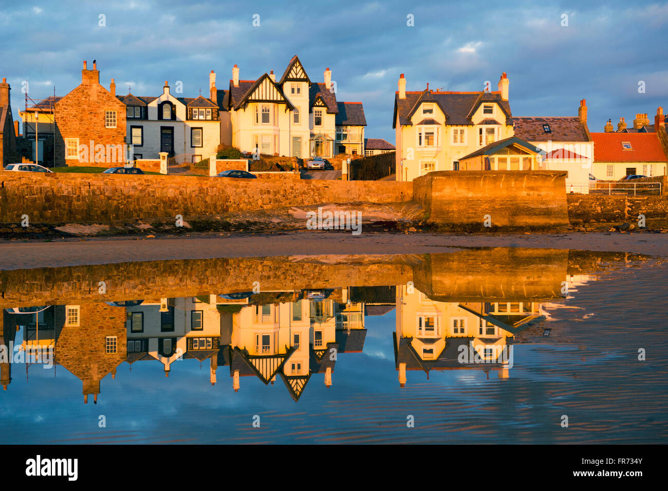 20.03.2016, geht die Sonne auf einer Häuserzeile spiegelt sich in dem Wasser bei Elie, eine Küstenstadt in der East Neuk of Fife, Schottland. Stockfoto