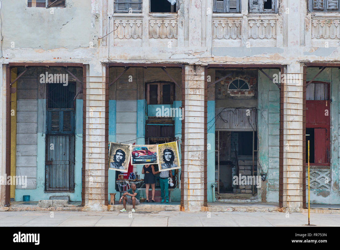 Poster von Che Guevara hängen zum Verkauf unter den verfallenden Fassaden Havannas Malecon. Stockfoto