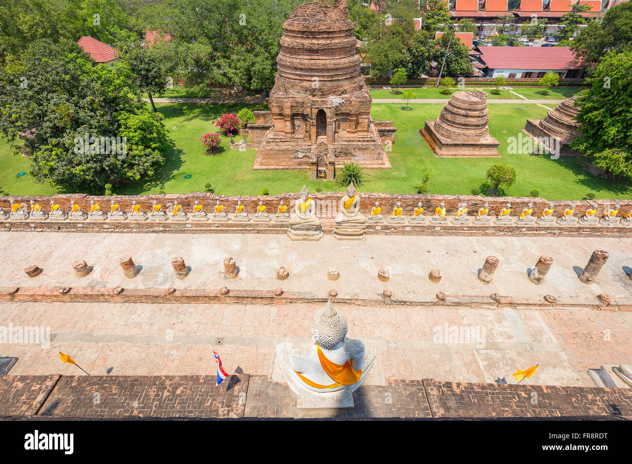 Draufsicht auf weiße Buddha-Statue und kleine Statue der Mönche im Wat Yai Chaimongkol von Ayutthaya, Thailand. Mit Hintergrund von pago Stockfoto