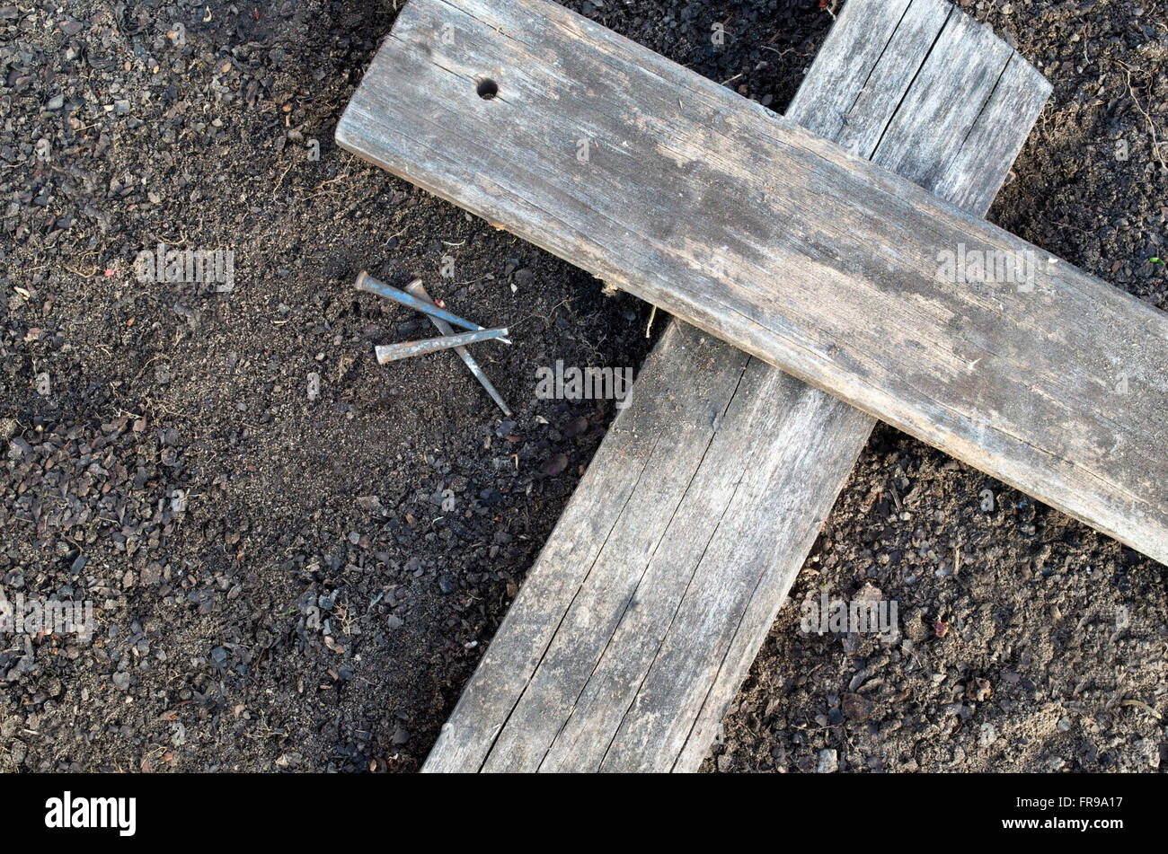 Hölzerne Kreuz Verlegung auf dem Boden mit drei Nägel in der Nähe Stockfoto