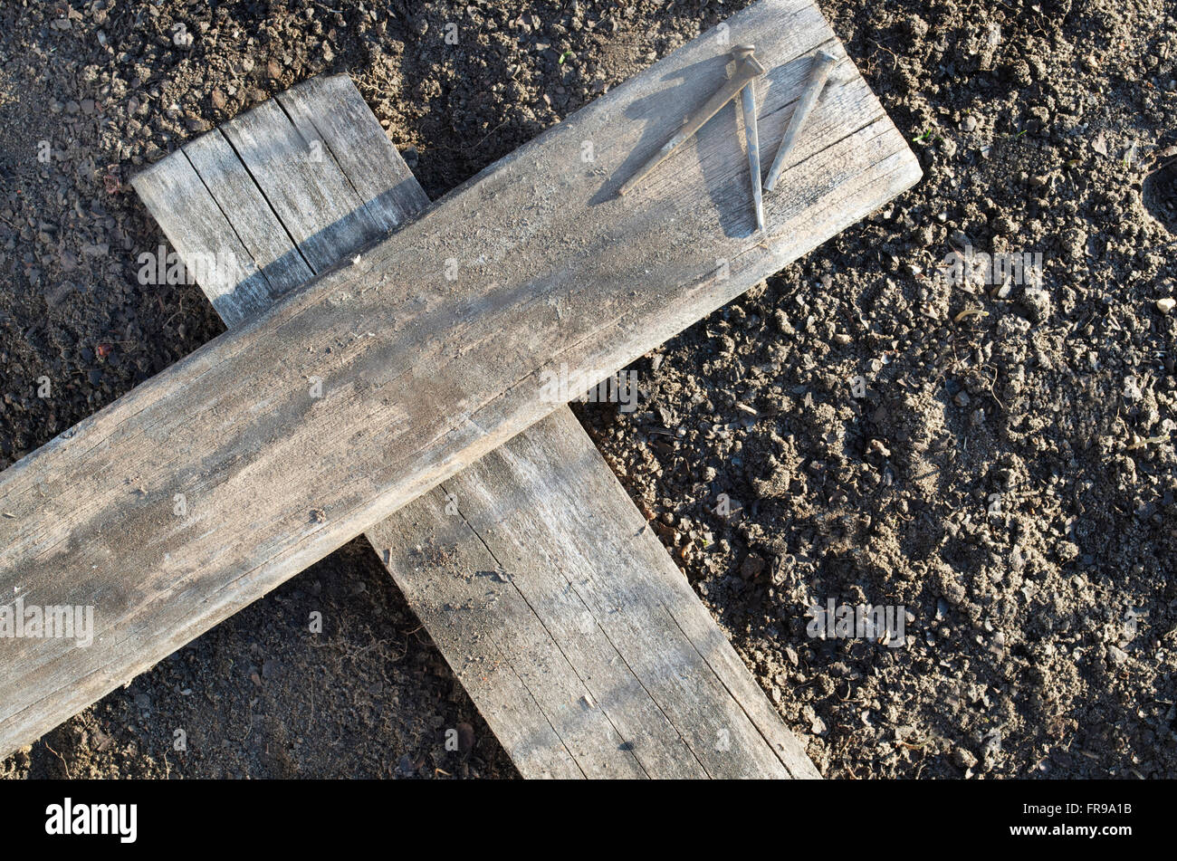 Hölzerne Kreuz Verlegung auf dem Boden mit drei Nägel in der Nähe Stockfoto