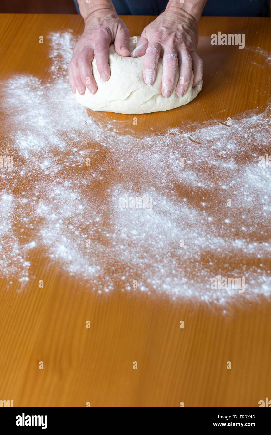 Hände eines männlichen Bäckers, die Herstellung von Brot auf dem Tisch Stockfoto